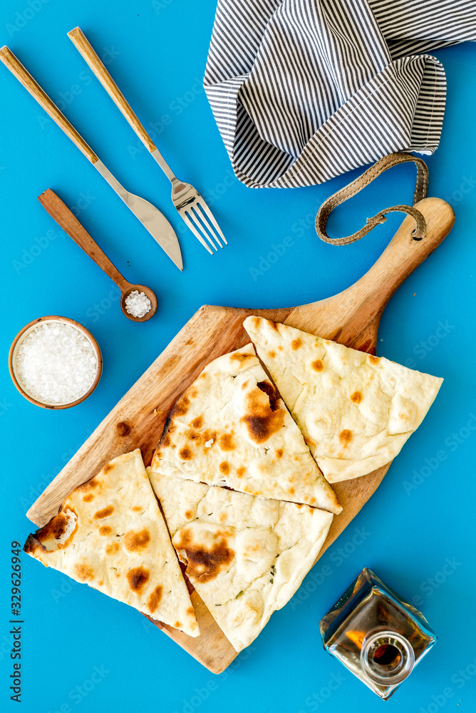 制作focaccia。传统的意大利面包，油从上到下放在蓝色桌子上