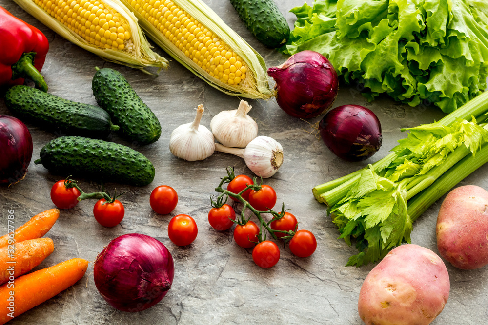 Fresh vegetables still life. Potato, cucumber, beet carrot, greenery on grey background