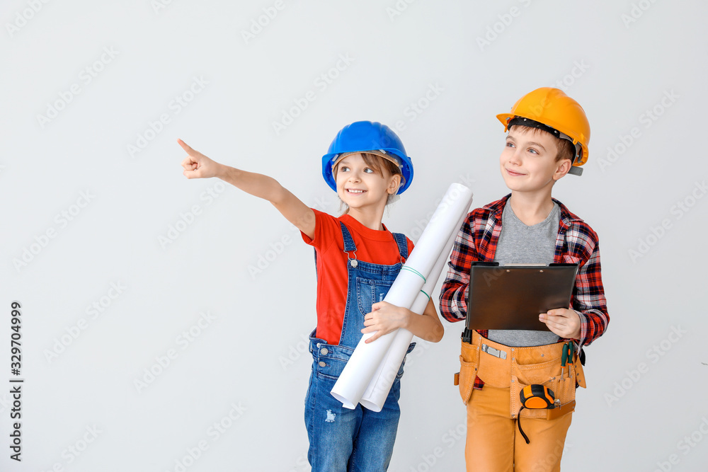 Cute little architects on light background