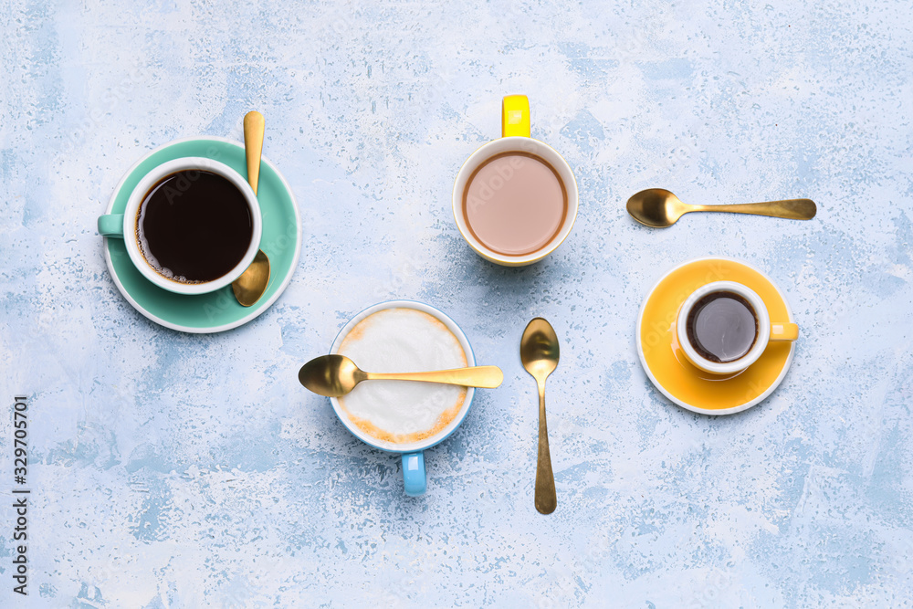 Composition with cups of different coffee on color background