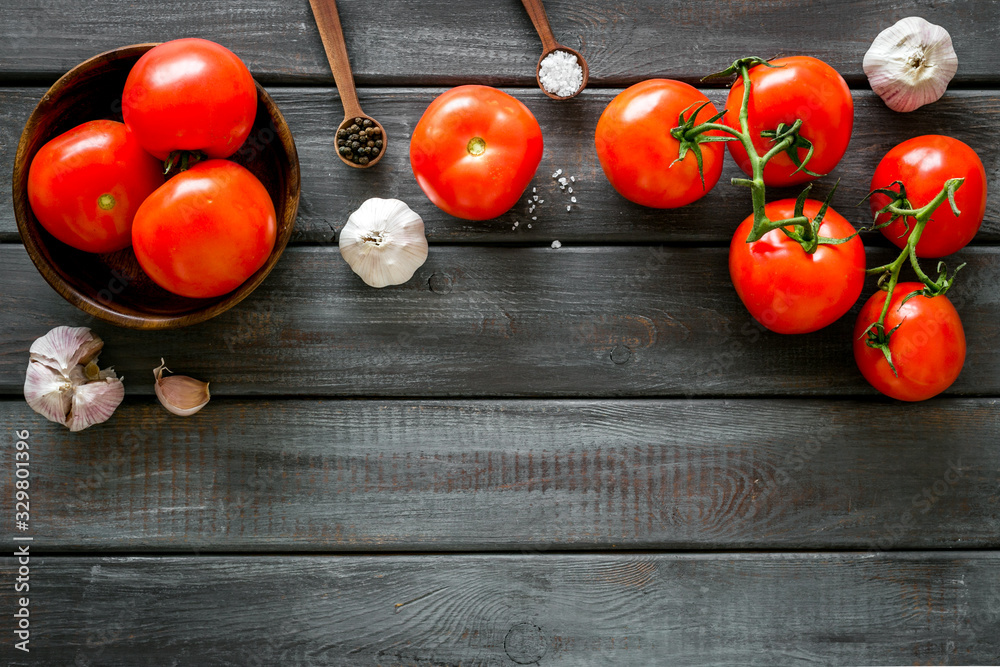 Tomatoes harvest. Vegetables near garlic, greenery and spices on wooden background top-down frame co