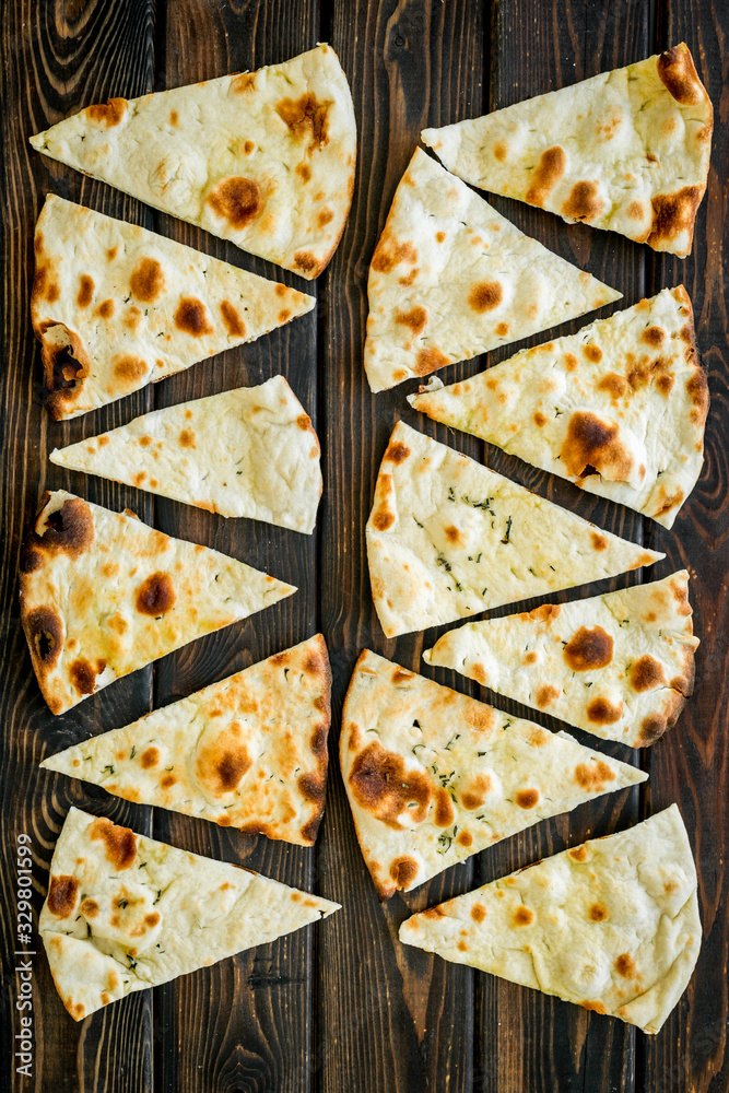 Focaccia pieces background on dark wooden table top-down