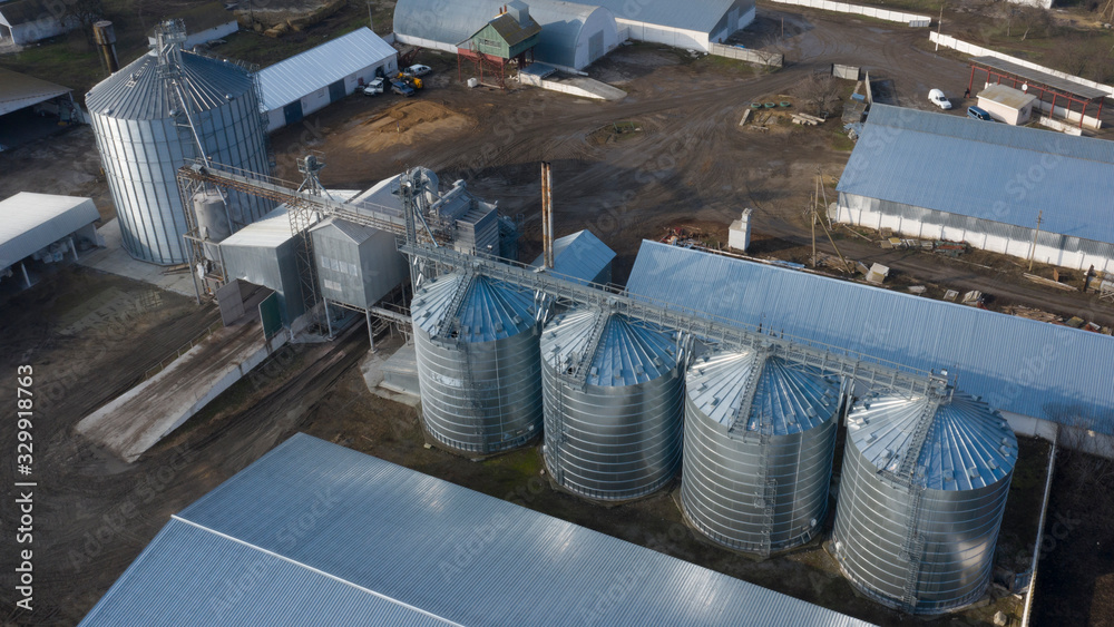 Large silver tanks of the elevator at the agro-industrial complex.