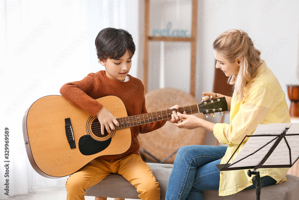 私人音乐老师在家给小男孩上吉他课