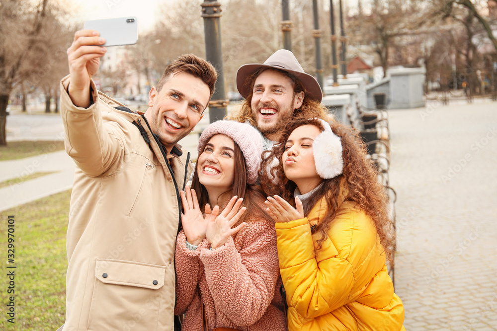 Happy friends taking selfie outdoors