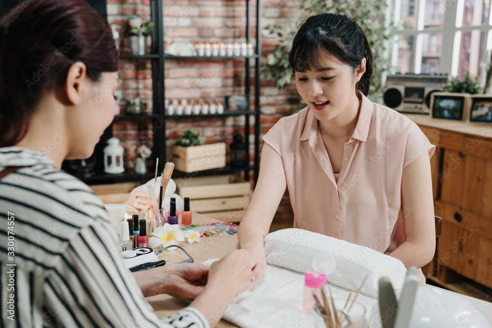 指甲设计美甲修脚美容和保健概念。女性美甲师检查客户的手