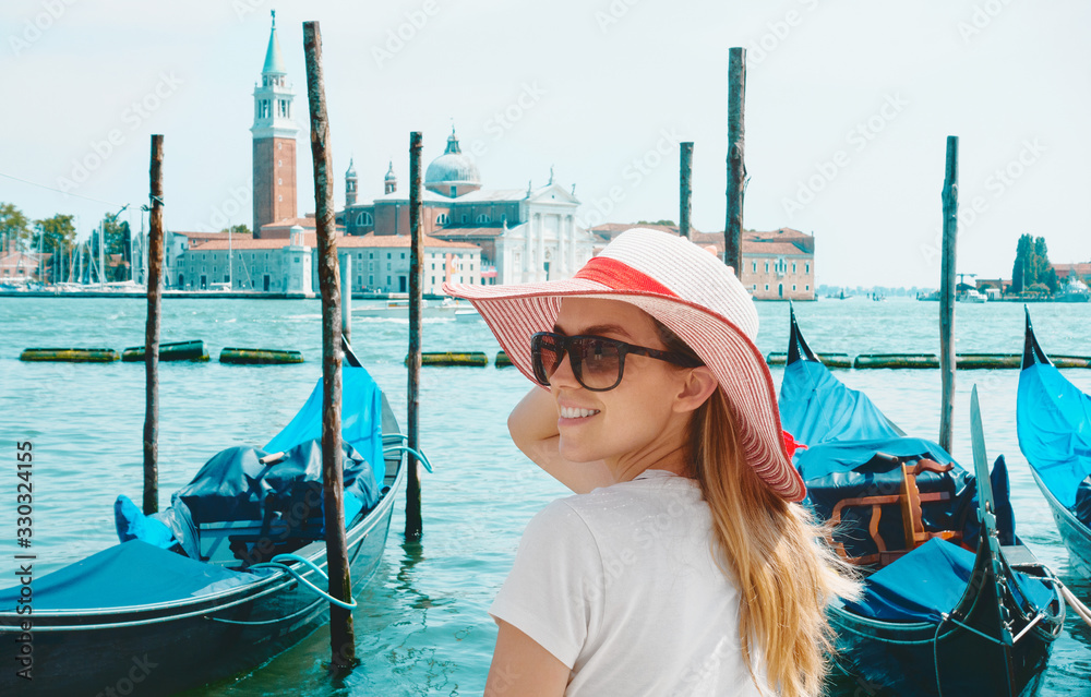 威尼斯Academia桥上戴着帽子的女旅行者在大运河上的景色。后视图