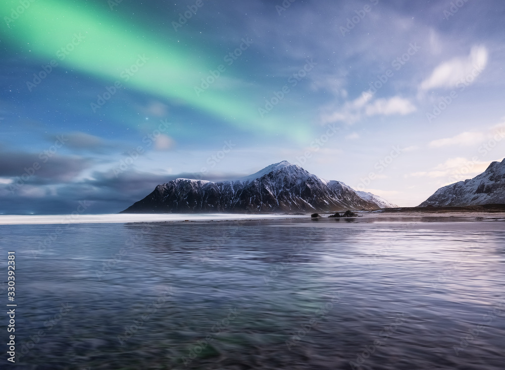 Aurora Borealis. Skagsanden beach on Lofoten Islands, Norway.. Stars and northern light. Reflections