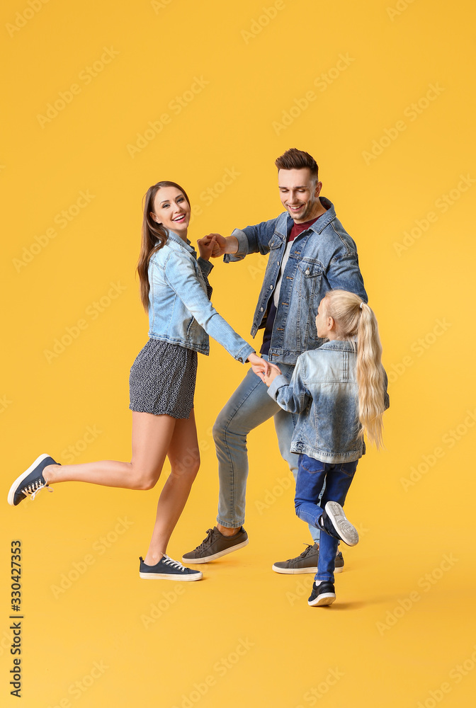 Happy family dancing against color background