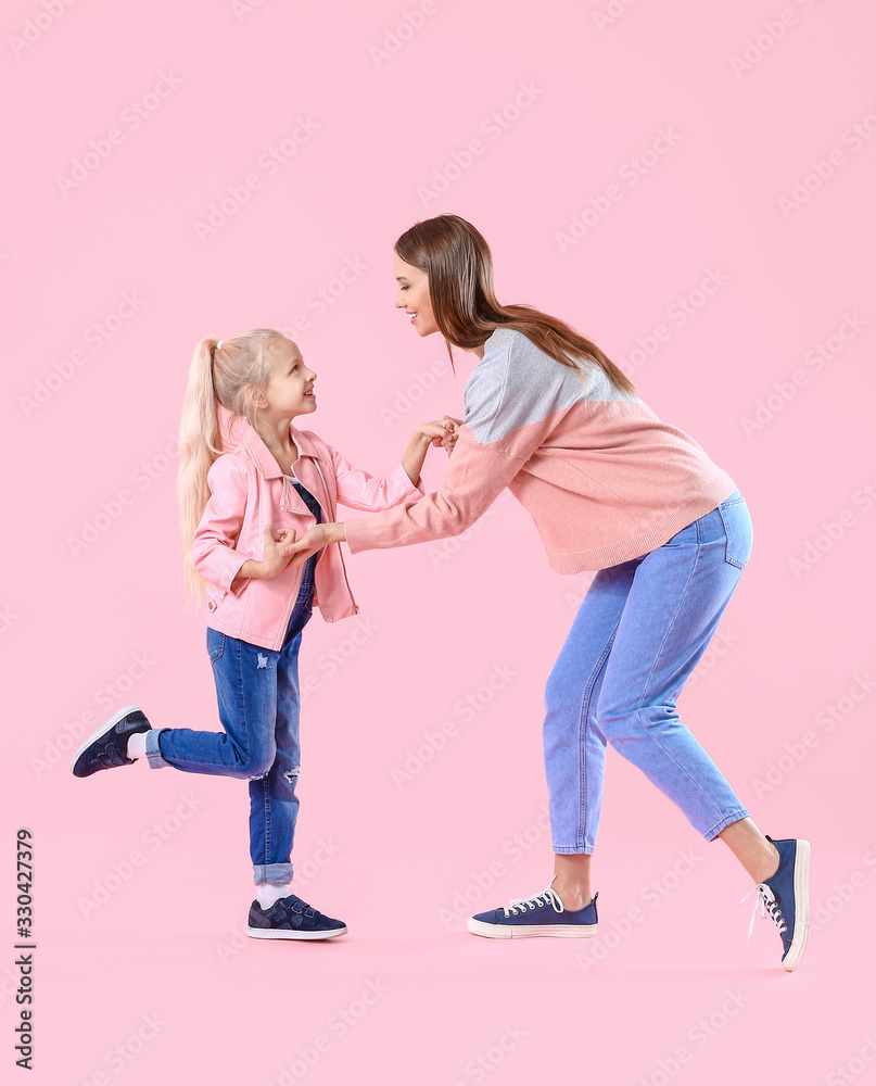 女人和她的小女儿在彩色背景下跳舞