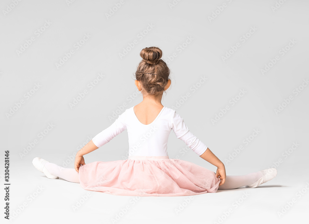 Cute little ballerina on light background