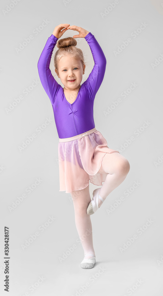 Cute little ballerina on light background