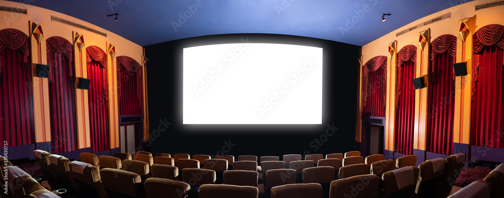 Cinema theater screen in front of seat rows in movie theater showing white screen projected from cin