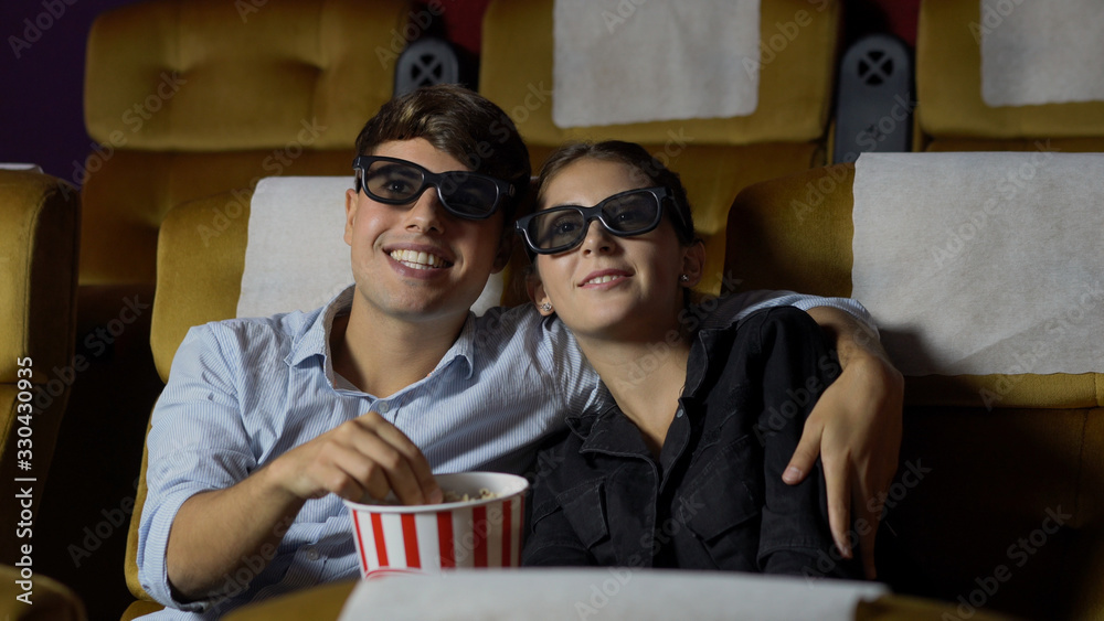 Man and woman in the cinema watching a movie with 3D glasses. with interest looking at the screen, e