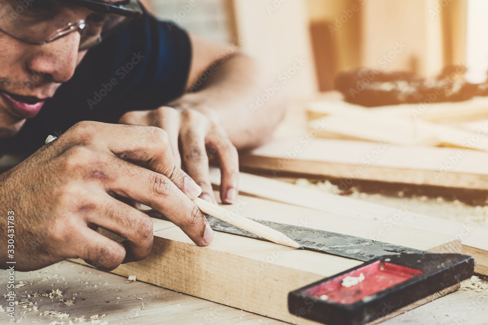 Carpenter working on wood craft at workshop to produce construction material or wooden furniture. Th