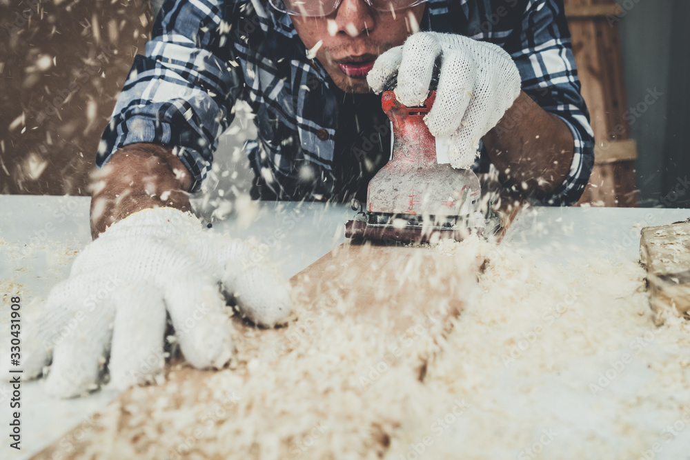 Carpenter working on wood craft at workshop to produce construction material or wooden furniture. Th