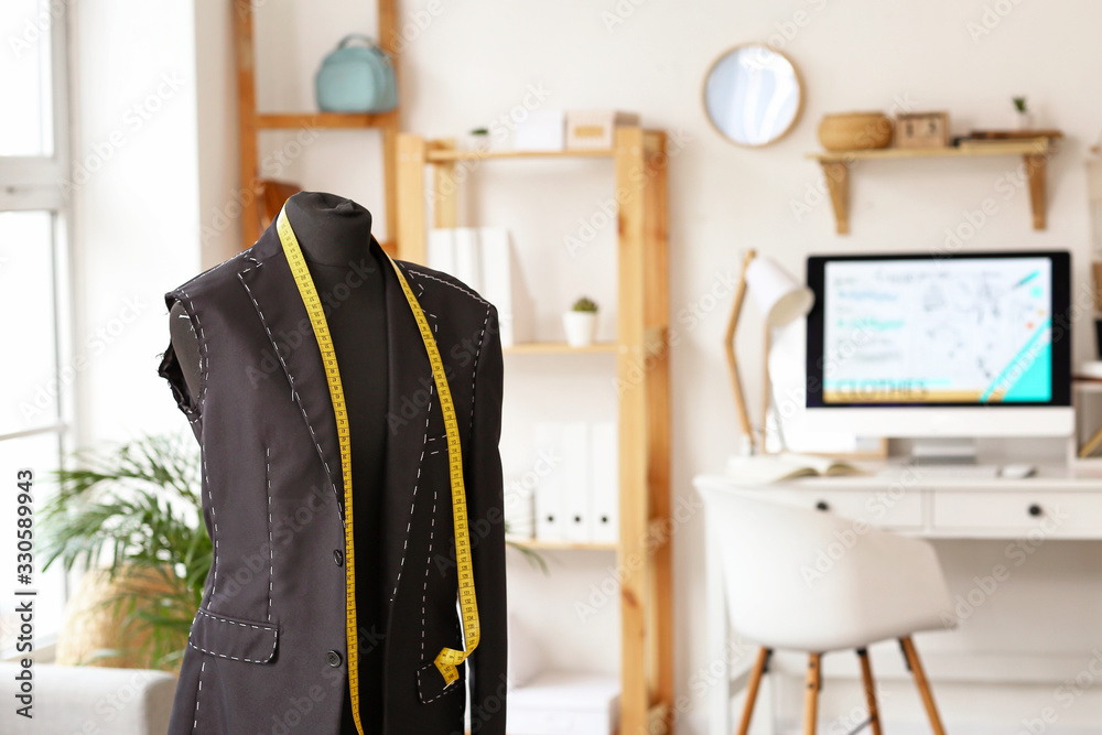 Mannequin with half-finished jacket and measuring tape in atelier