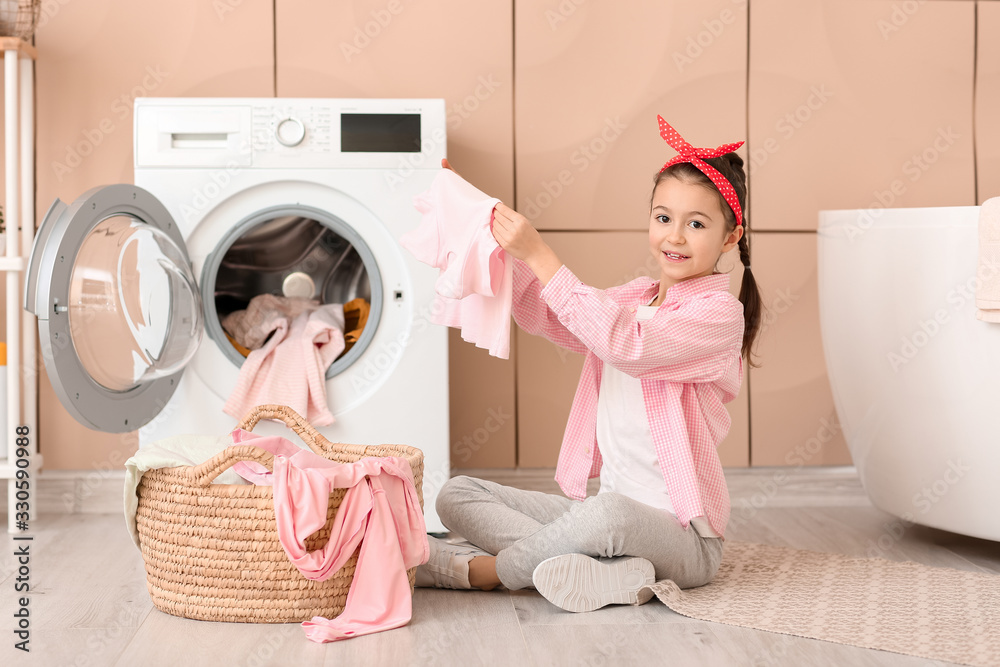 Little housewife with laundry at home