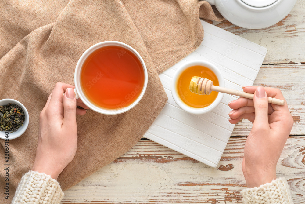 女人在餐桌上喝蜂蜜茶，俯视图