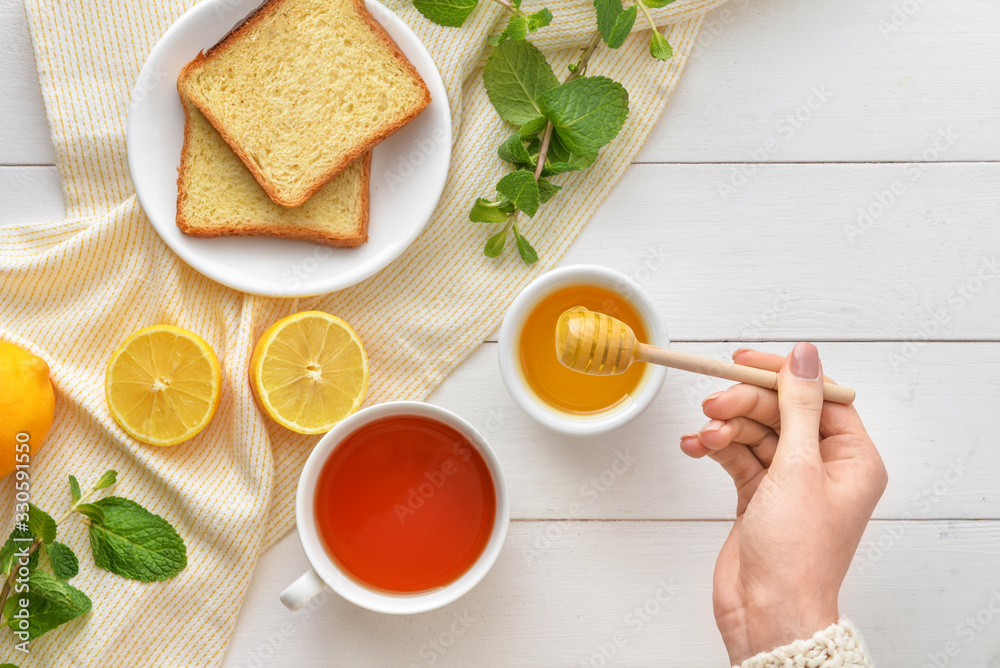 女人在餐桌上喝蜂蜜茶，俯视图