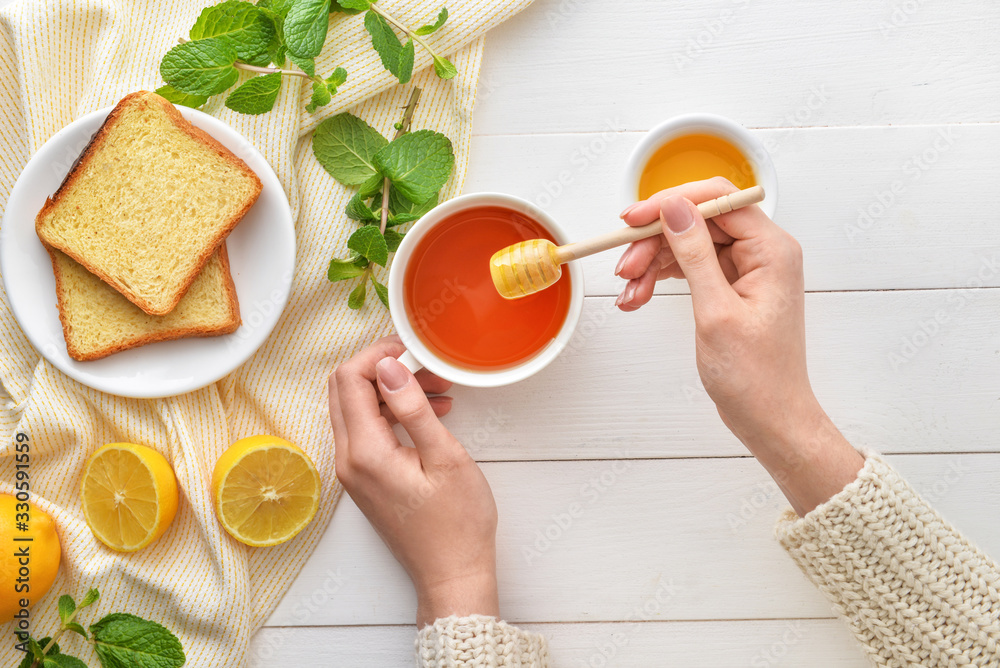 女人在餐桌上喝蜂蜜茶，俯视图