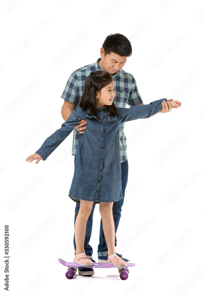 Happy Asian man and his little daughter with skateboard on white background