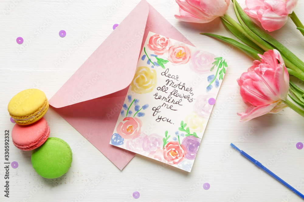 Composition with greeting card for mother on white wooden background