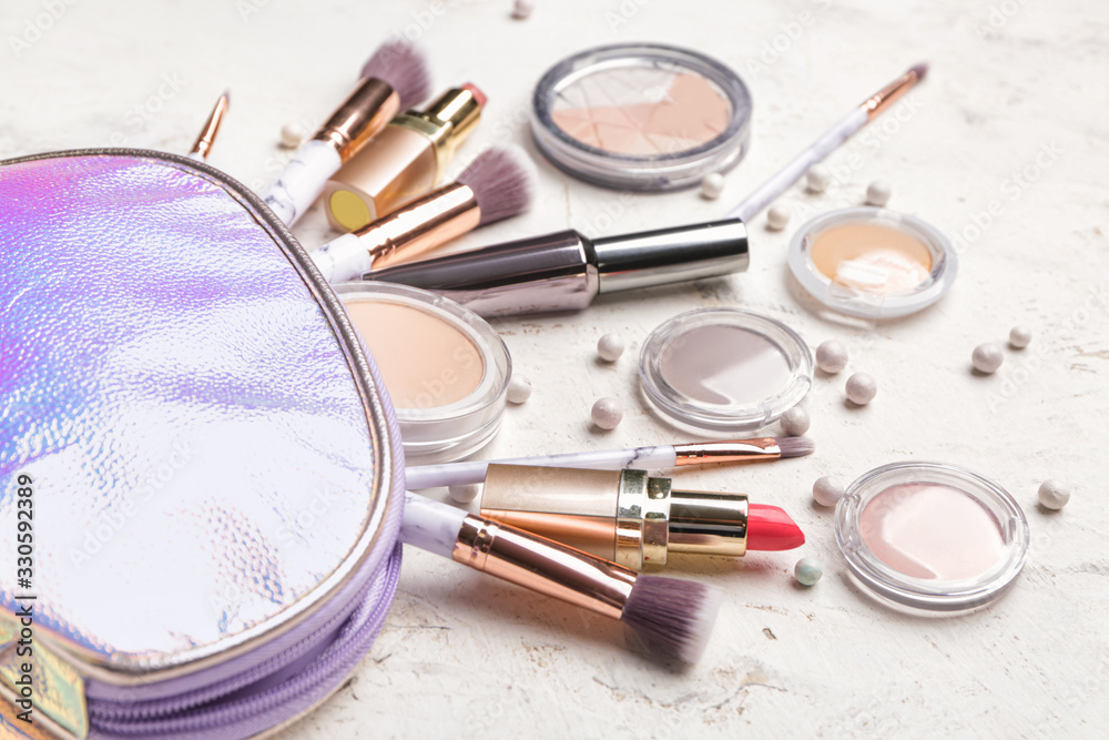 Bag with makeup brushes and decorative cosmetics on white background