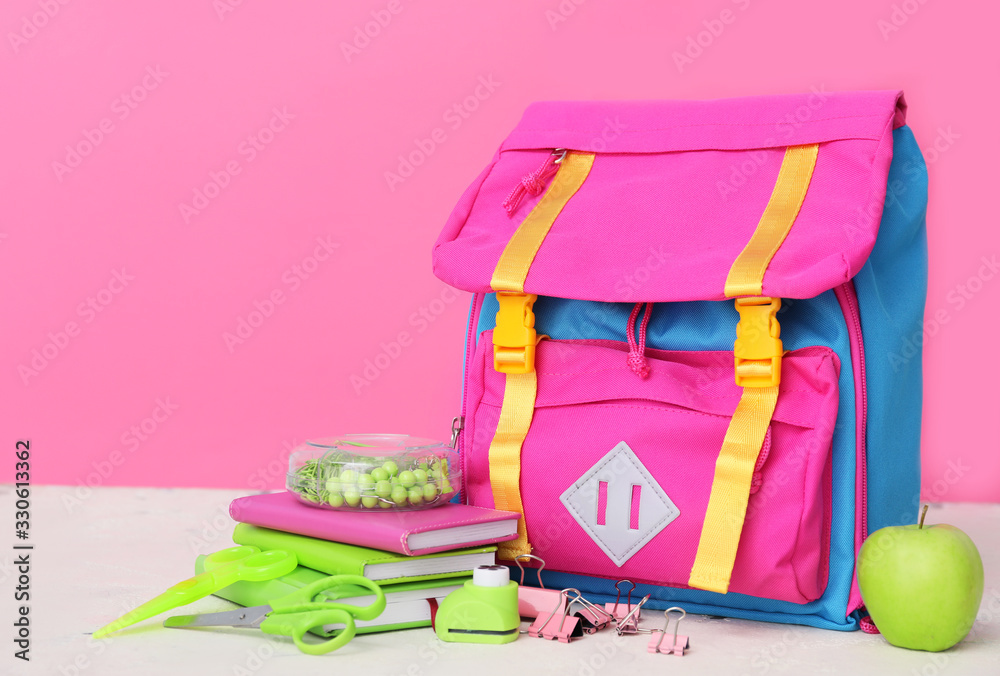 School backpack and stationery on table