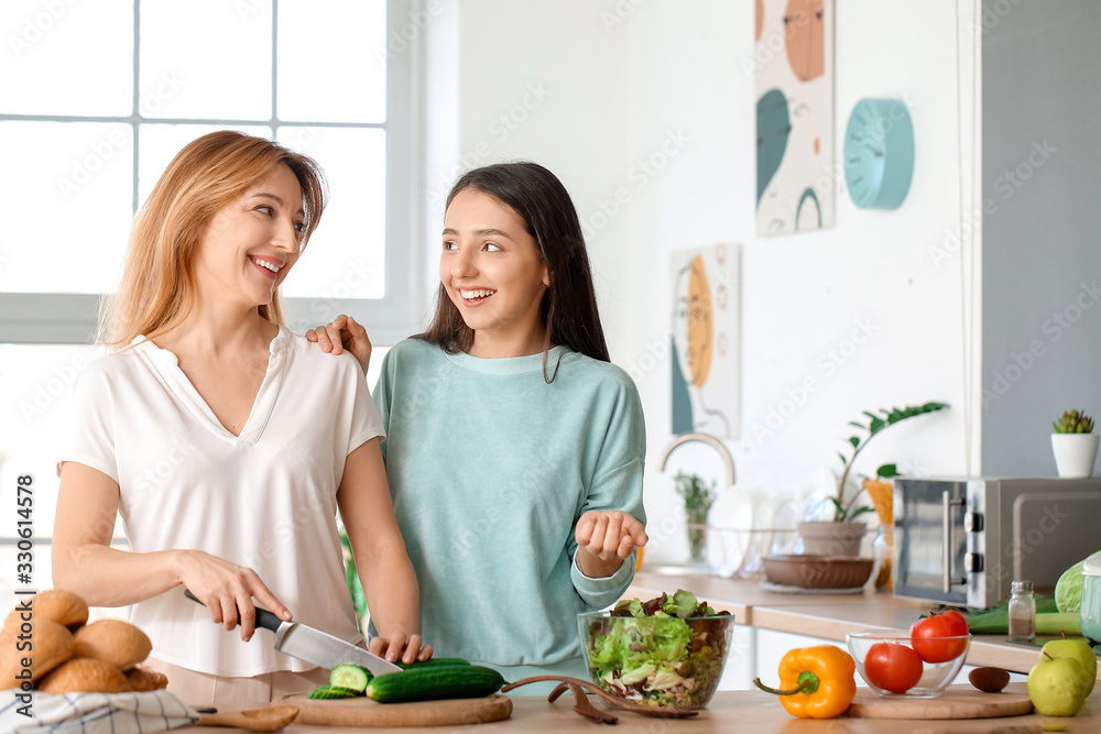 成熟的女人和她成年的女儿在家一起做饭