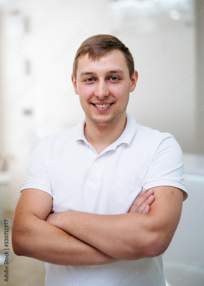 Portrait of a smiling doctor. Male surgeon with operation room background.