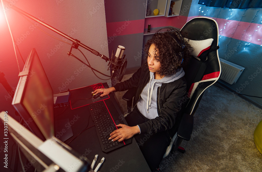 Rear view of female dj working in front of a microphone on the radio.