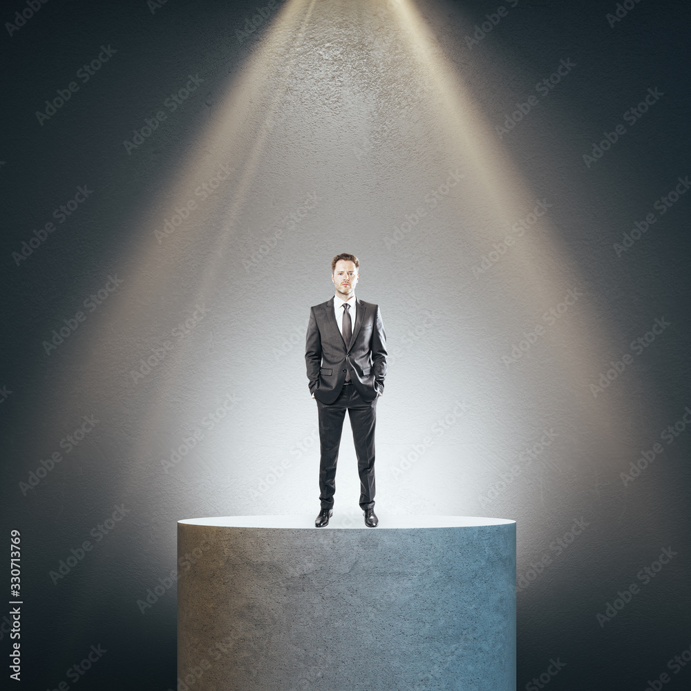 Businessman standing on concrete pedestal