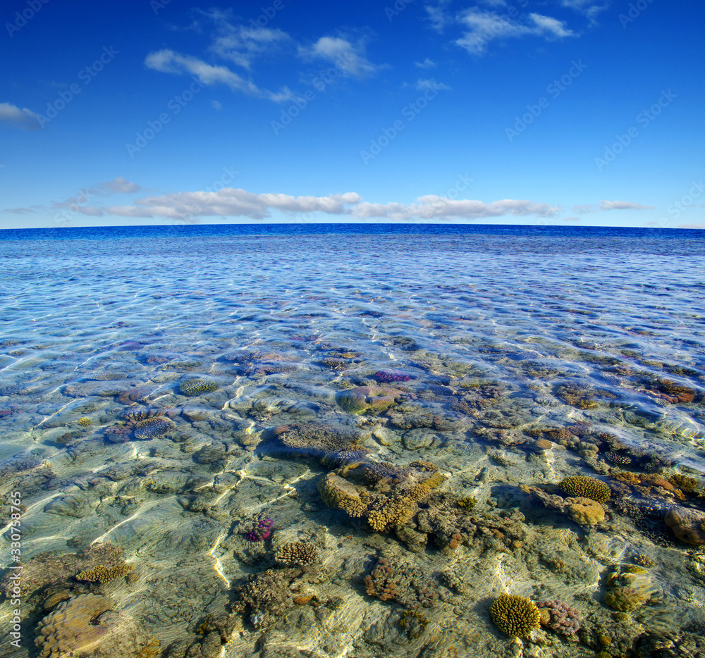 Sea with coral reef and clouds