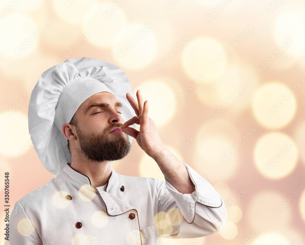 Professional chef man in uniform showing sign for delicious.