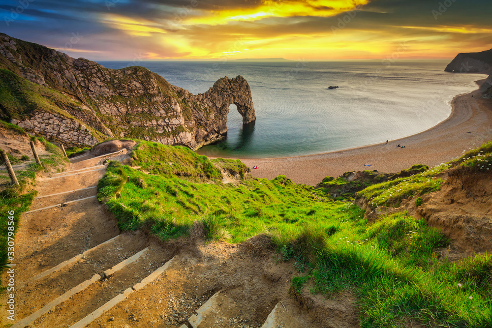 日落时分，英国多塞特侏罗纪海岸海滩上的Durdle Door