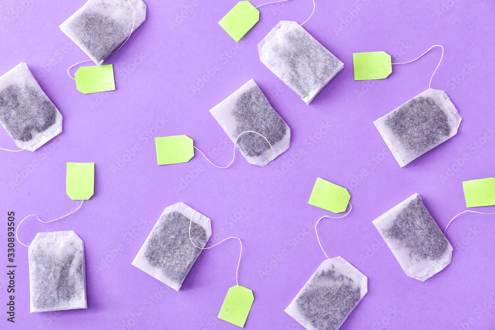 Many tea bags on color background