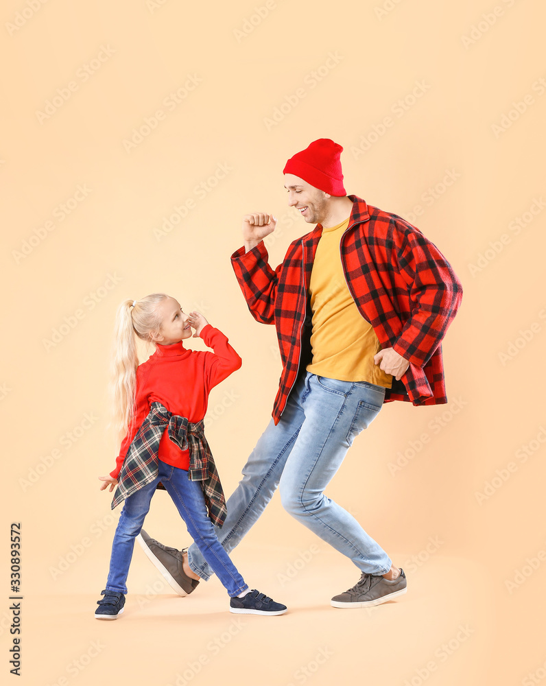 Happy man and his little daughter dancing against color background