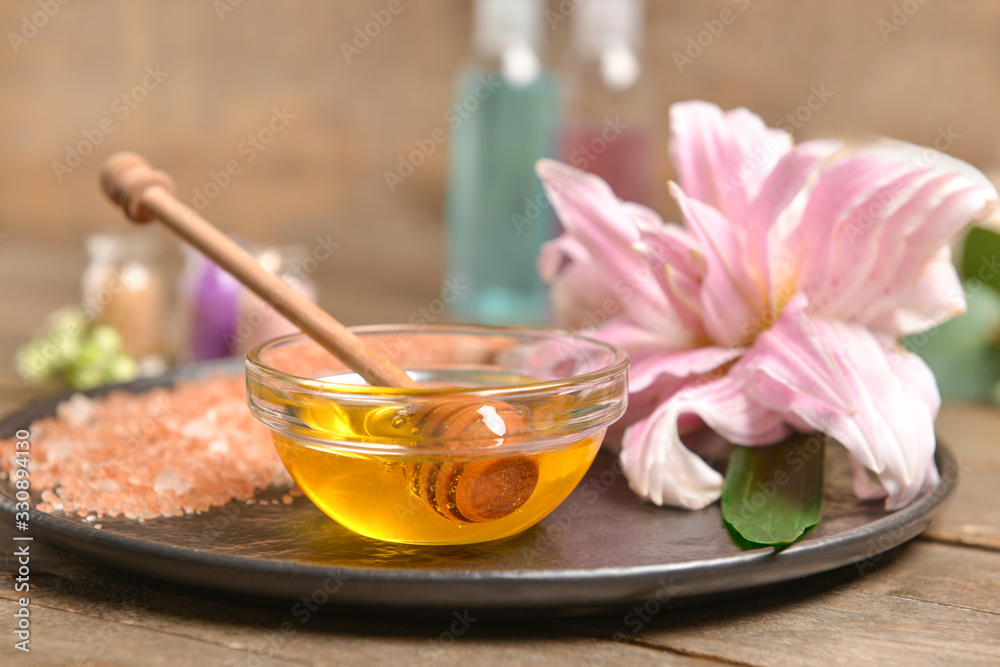 Tray with honey and sea salt on table