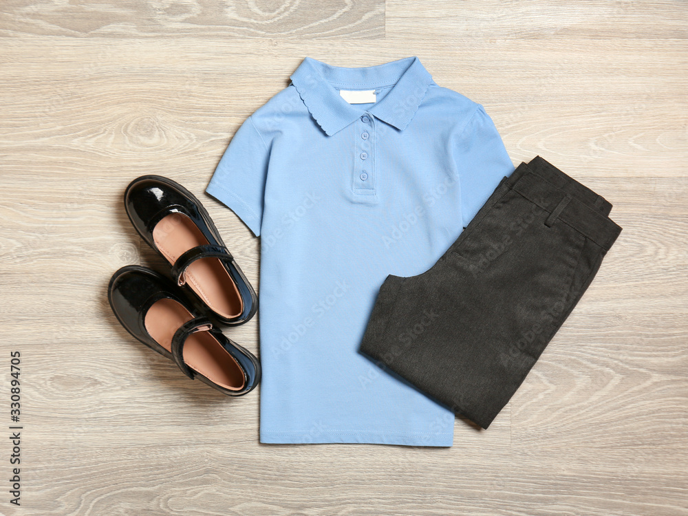 Stylish school uniform on wooden background