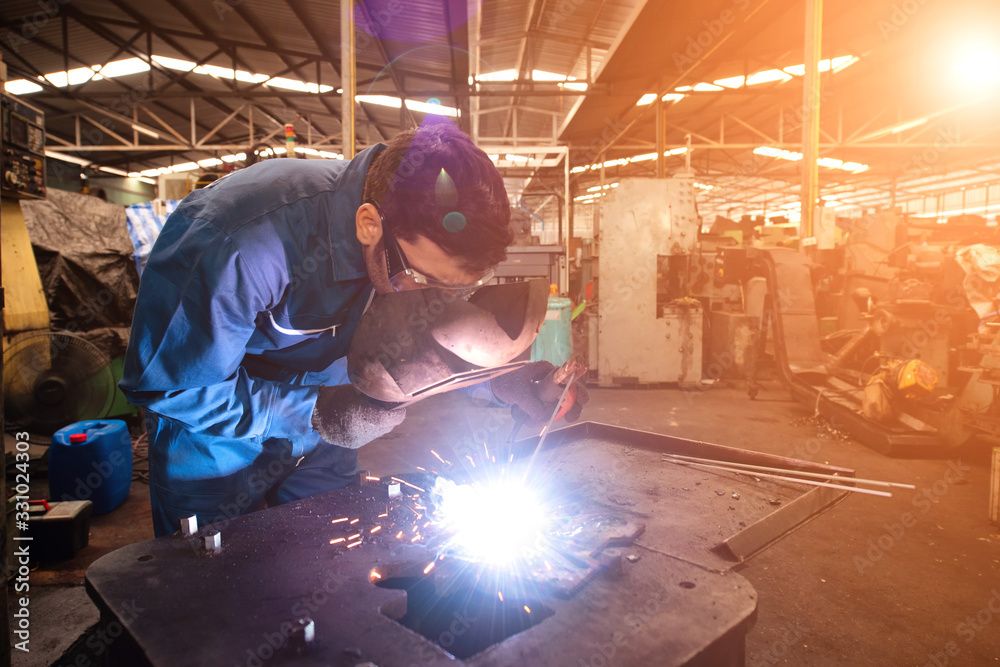 The welder is working in the factory.