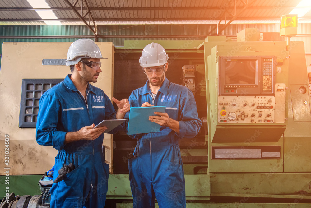 Industrial engineers are talking. They work at the heavy Industry manufacturing facility.