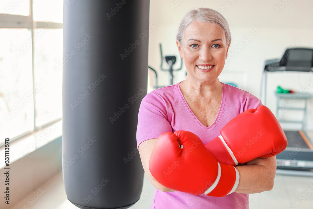 Sporty mature female boxer in gym