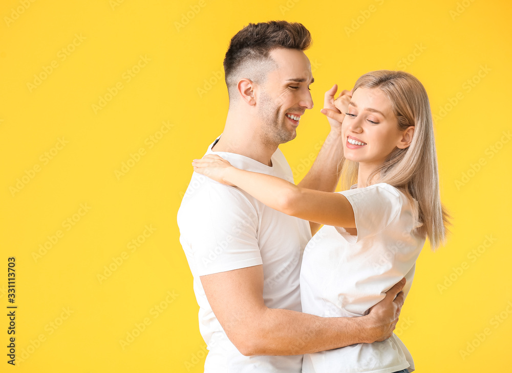 Happy dancing young couple on color background