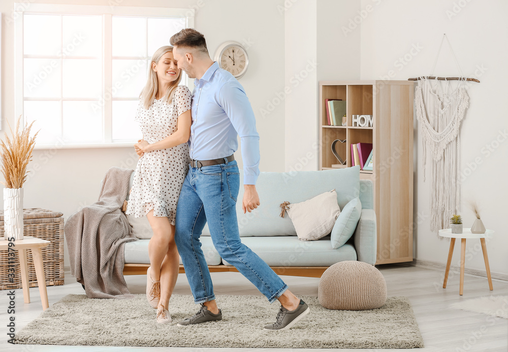 Happy dancing young couple at home