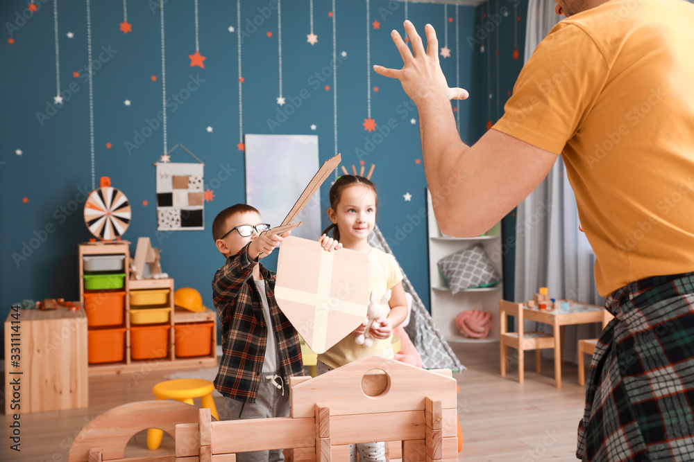 Father and little children playing with take-apart house at home