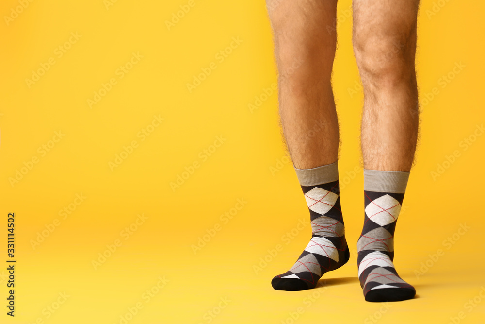 Male legs in socks on color background