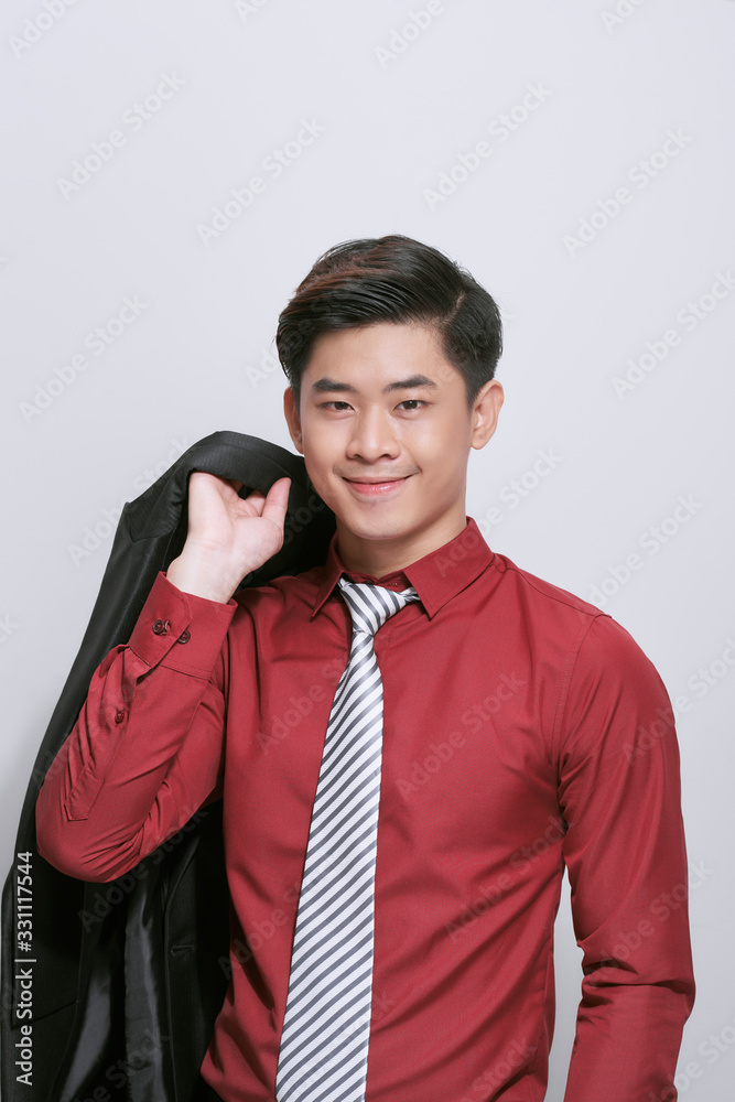 Aisan businessman holding coat over shoulder