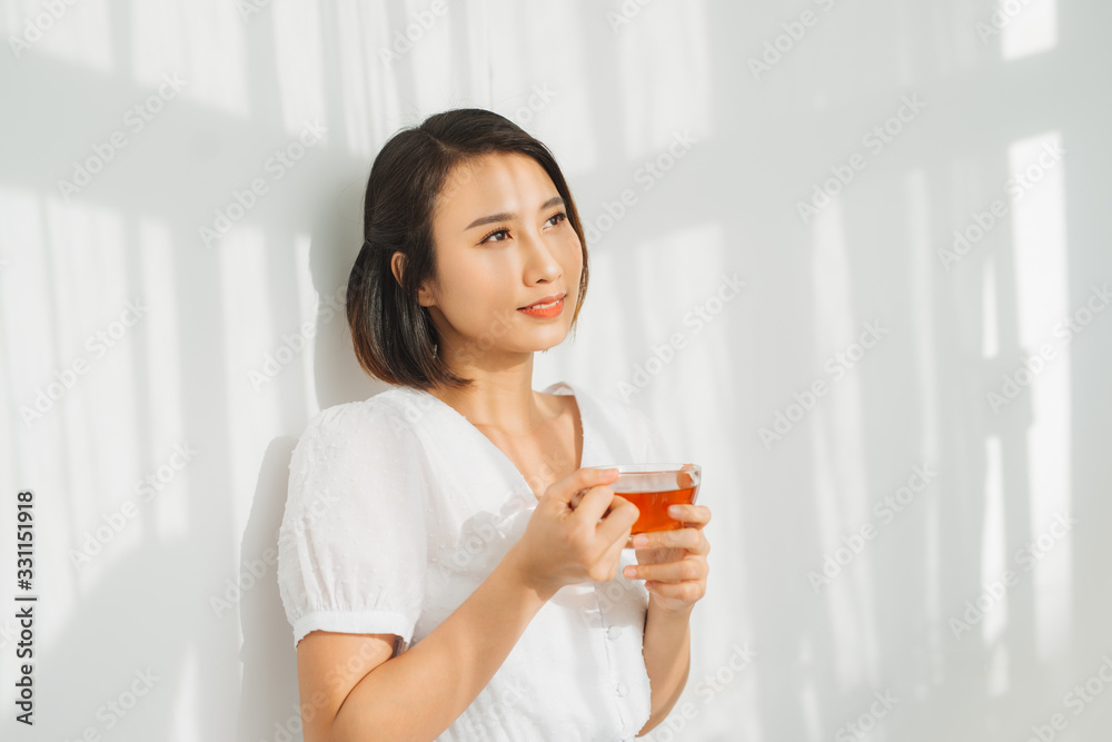 Happy woman thinking and looking at side beside a window at home