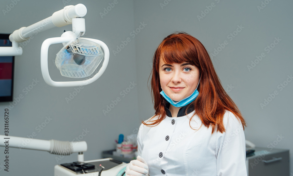 Attractive female dentist posing in modern dental office. Medicine, health, stomatology concept.